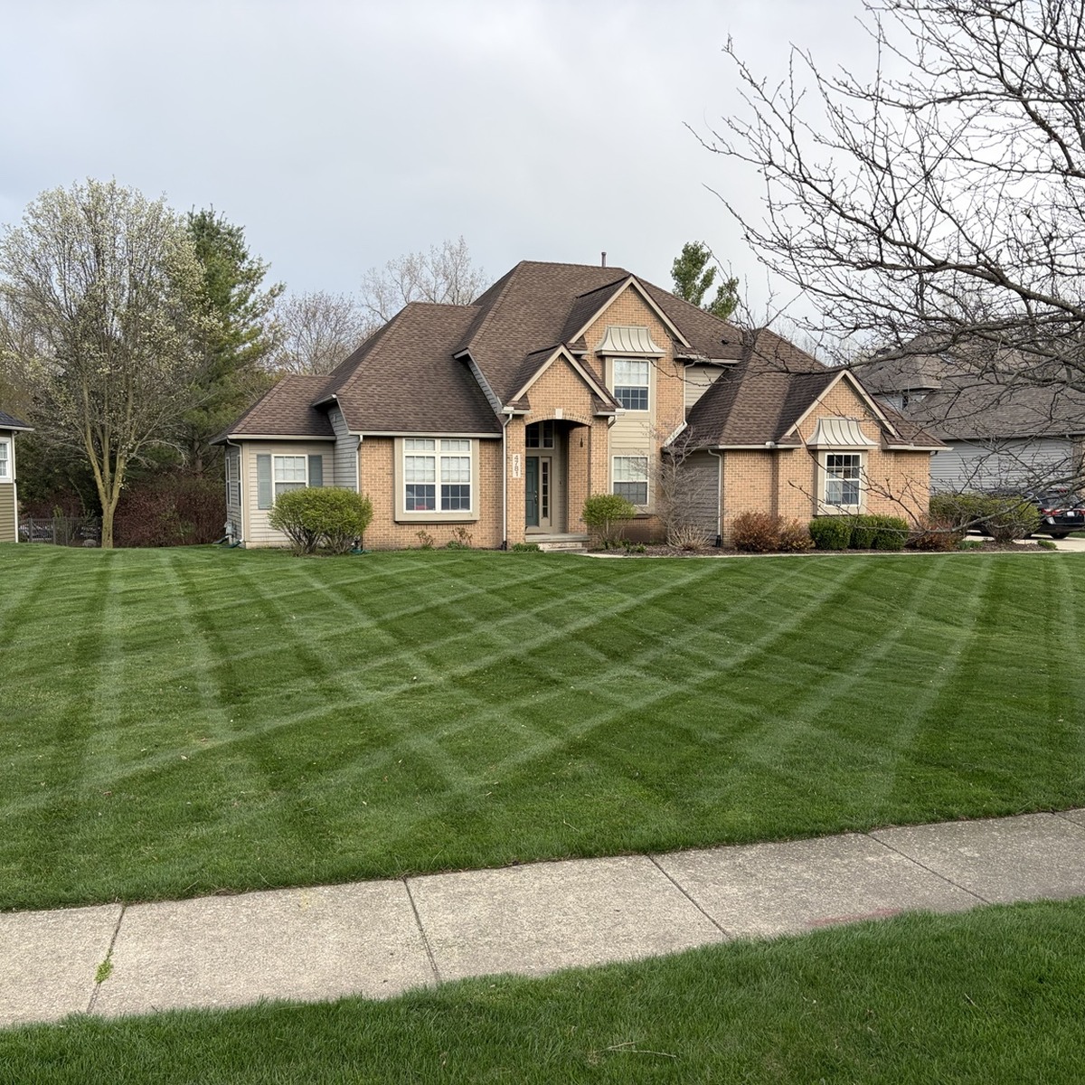 Mowed lawn with a crosshatch pattern in front of a home